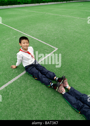 Schulkinder, die Dehnung während einer körperlichen Fitness-Klasse Stockfoto