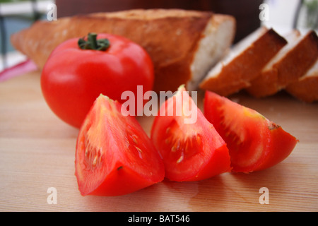 Nahaufnahme von frischen Tomatenscheiben und knuspriges Weißbrot auf einem hölzernen hacken an Bord Stockfoto