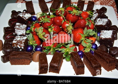 Dessert-Schale mit Erdbeeren iced Schokoladen-Brownies Sortiment fancy eingetauchte dunkle Milchschokolade Stockfoto