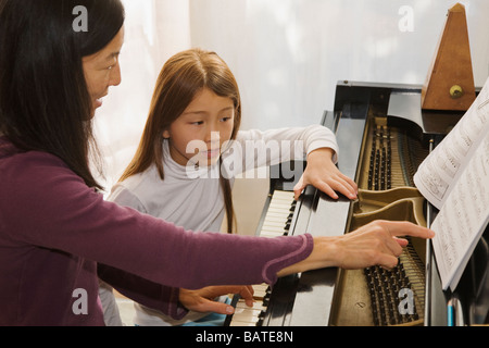 Frau unterrichtet Klavier, junge Mädchen Stockfoto