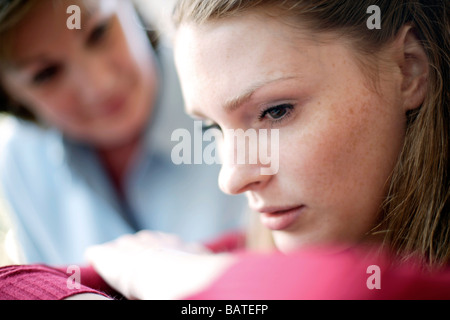 Unglückliche junge Frau wird von ihrer Mutter getröstet. Stockfoto