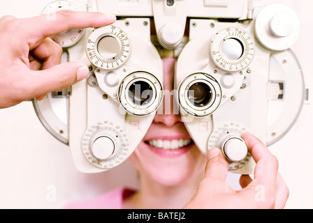 Augenuntersuchung. Optiker mit einem Phoropter, um ein zehn Jahre altes Mädchen Augen zu untersuchen. Stockfoto