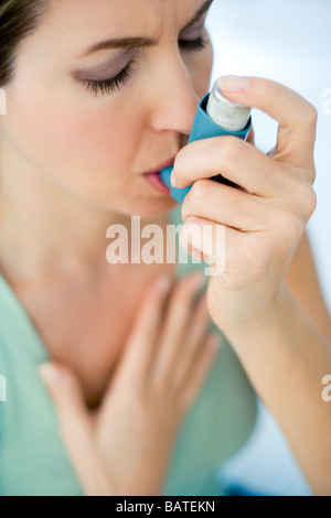 Asthma-Inhalator verwenden. Frau mit einem Inhalator, um einen Asthma-Anfall zu behandeln. Stockfoto