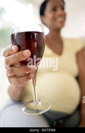 Schwangere Frau mit einem Glas Rotwein. Sie ist auf volle Amtszeit. Stockfoto