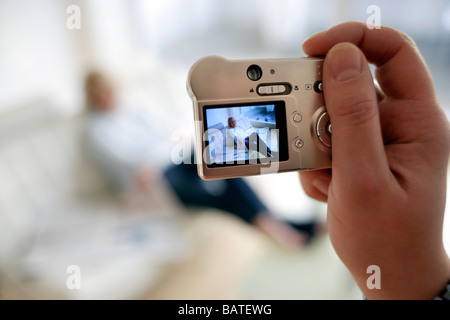 Digital-Kamera verwenden. Mann, der ein Foto von einer Frau mit einer digitalen Kamera. Stockfoto