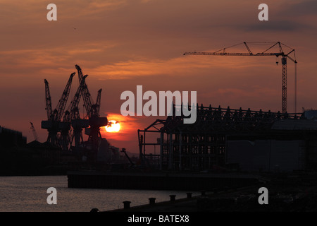 Sonnenuntergang über der alten Krane auf BAE Systeme Werft neben dem Fluss Clyde in Govan, Glasgow, Schottland, Großbritannien Stockfoto