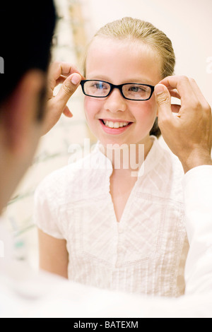 Wählen ein paar Gläser. Optiker helfen, ein Zehn Jahres altes Mädchen ein paar Gläser zu wählen. Stockfoto