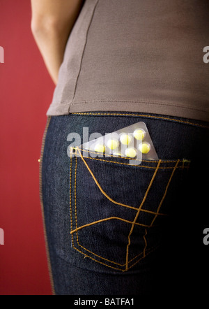 junge Frau mit einem Blister Tabletten im backpocket Stockfoto