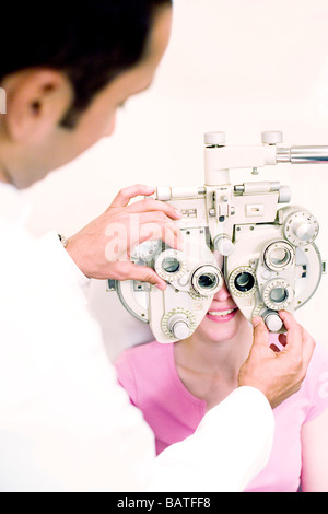 Augenuntersuchung. Optiker mit Aphoropter, eine Frau zu prüfen Stockfoto