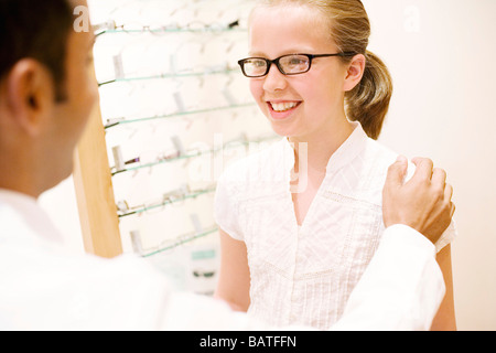 Wählen ein paar Gläser. Optiker helfen, ein Zehn Jahres altes Mädchen Apair Brille wählen. Stockfoto