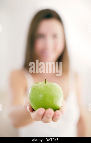 Apfel statt in die Hand einer Frau. Stockfoto