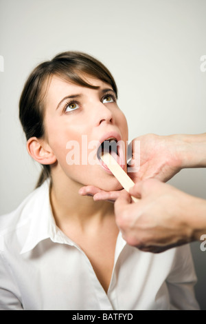 Arzt und Patient mit Zunge depressor Stockfoto