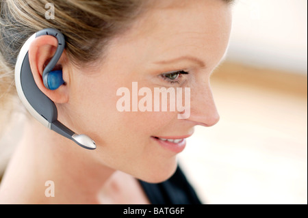 Drahtlose Kommunikation. Frau trägt ein Handy Kopfhörer. Stockfoto