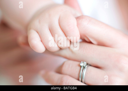 Mutter und Baby. 7 Monate alten Babygirl ihrer Mutter Finger festhalten. Stockfoto