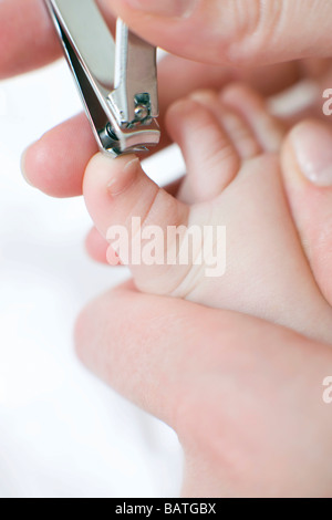 Fußnägel schneiden. 7 Monate altes Baby-Mädchen, das ihre Fußnägel schneiden. Stockfoto