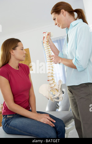 Chiropraktiker und Patienten. Die Chiropraktiker ist ein Modell der Wirbelsäule des Patienten ihr verwenden. Stockfoto