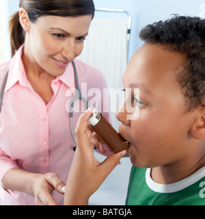 Asthma-Inhalator verwenden. Arzt anweisen ein Junge wie einen Asthma-Inhalator benutzen. Stockfoto