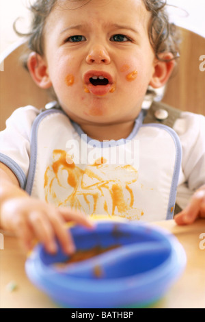 Baby Junge Essen. 9 Monate altes Baby junge spielt mit seiner Nahrung. Babys Startpicking bis zu ca. 7 Monate alt Essen. Stockfoto