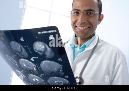 Arzt hält MRI-Scans. Die Scans sind sagittale (vertikal und seitlich) Abschnitte durch den Patienten Kopf. Stockfoto