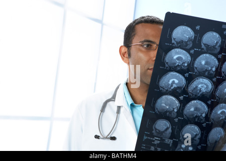 Arzt hält MRI-Scans. Die Scans sind sagittale (vertikal und seitlich) Abschnitte durch den Patienten Kopf. Stockfoto