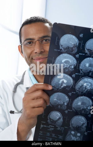 Arzt hält MRI-Scans. Die Scans sind sagittale (vertikal und seitlich) Abschnitte durch den Patienten Kopf. Stockfoto