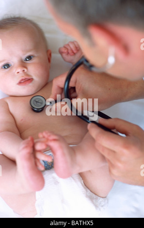 Baby und Arzt. Arzt Usinga Stethoskop zum Abhören der Brust (Andlung Herztöne) ein 4 Monate altes baby Stockfoto