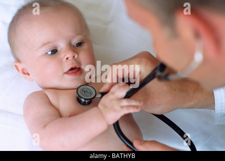 Baby und Arzt. Arzt Usinga Stethoskop zum Abhören der Brust (Andlung Herztöne) ein 4 Monate altes baby Stockfoto