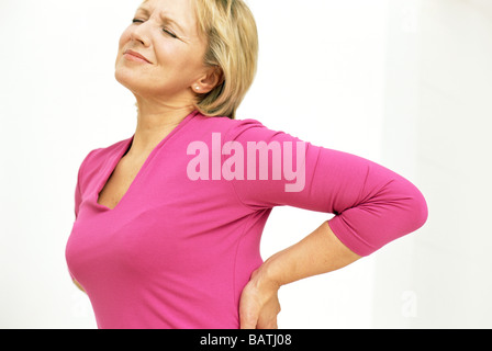 Schmerzen im unteren Rücken. Womanholding ihre schmerzhafte unteren Rücken. Stockfoto