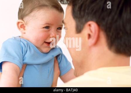 Baby und Vater. Lächelndes Gesicht eines 6 Monate alten Baby-jungen, von seinem Vater aufgehoben ist. Stockfoto