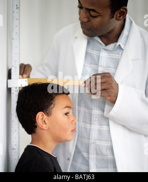 Höhenmessung. 7 Jahre alten Sohn mit seiner Höhe von einem Arzt gemessen. Stockfoto