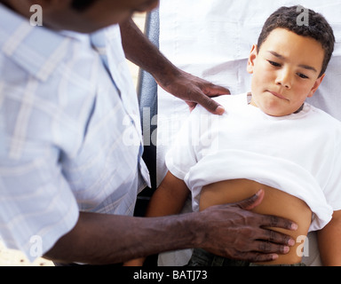 Bauch-Prüfung. Allgemeinmedizin Arzt untersucht eine 9-Year-Old boy'sabdomen. Stockfoto