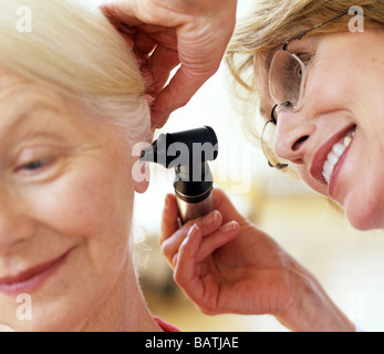 Ohr-Prüfung. Arzt für Allgemeinmedizin mit einem Otoskop, um Anelderly Patienten Ohr zu untersuchen. Stockfoto