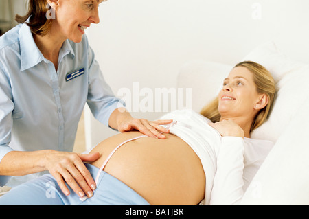 Geburtshilfliche Untersuchung. Hebamme, die Messung einer schwangeren Bauch. Stockfoto