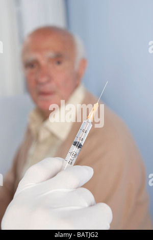 Injektion. Arzt eine Spritze, ein älterer Patient Berechtigungsverhalten wird vorbereitet. Stockfoto