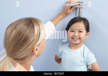 Kind-Höhenmessung. Arzt messen der Höhe eines jungen Mädchens während einen Check-up. Stockfoto