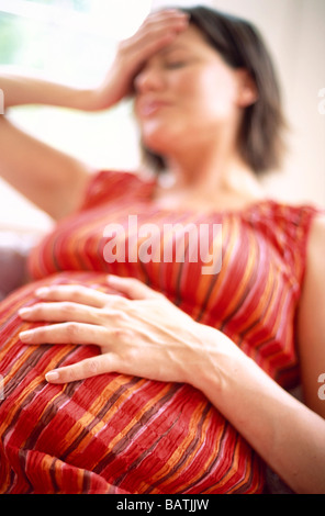 Schwangere Frau hält ihren Kopf, als ob es leid oder Schmerzen. Sie ist acht Monate (32 Wochen) schwanger. Stockfoto