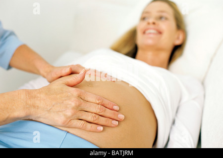 Geburtshilfliche Untersuchung. Hebamme, die Messung einer schwangeren Bauch. Stockfoto