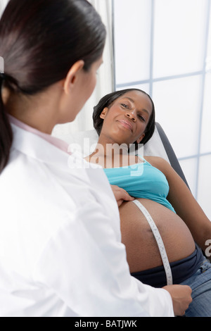 Geburtshilfliche Untersuchung. Arzt einer schwangeren Bauch drücken. Stockfoto
