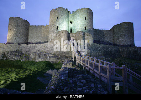 Stadt von Harlech, Wales. Nacht mit Blick auf die Ostansicht und das äußere Tor des späten 13. Jahrhunderts Harlech Castle Flutlicht. Stockfoto