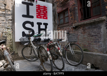 Fahrräder geparkt vor einem ich liebe Shanghai Zeichen in einer Gasse in Shanghai China Stockfoto