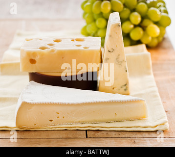 Stück Käse mit Trauben auf Hintergrund Stockfoto