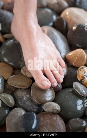 Nahaufnahme des Weibes Fuß auf Kieselsteinen Stockfoto