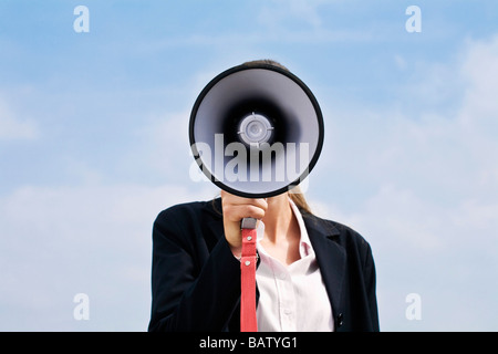 Porträt des jungen Geschäftsfrau versteckt hinter Megaphon Stockfoto