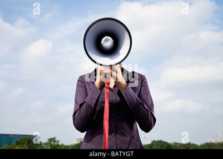 Porträt des jungen Geschäftsfrau versteckt hinter Megaphon Stockfoto