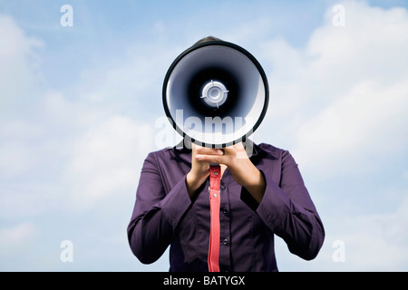 Porträt des jungen Geschäftsfrau versteckt hinter Megaphon Stockfoto