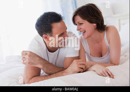 Paar auf Bett nebeneinander liegend Stockfoto