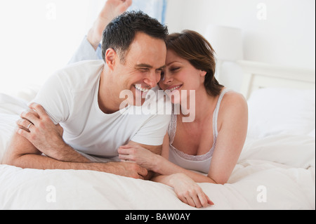 Paar auf Bett nebeneinander liegend Stockfoto