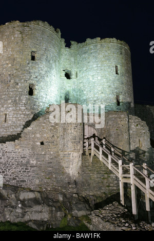 Stadt von Harlech, Wales. Nacht mit Blick auf die Ostansicht und das äußere Tor des späten 13. Jahrhunderts Harlech Castle Flutlicht. Stockfoto