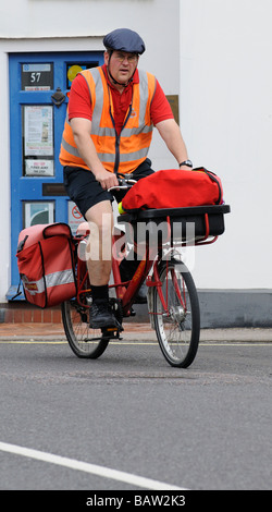 Postbote Radfahren auf seine Royal Mail Route Kopfschutz tragen Stockfoto