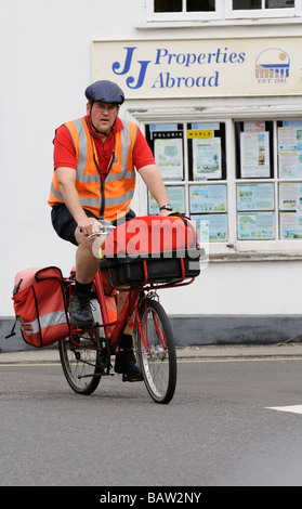 Postbote Radfahren auf seine Royal Mail Route Kopfschutz tragen Stockfoto